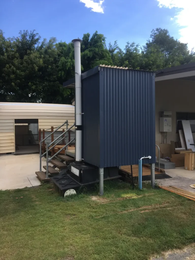 Rear view of single-cubicle facility showing Clivus Multrum CM8 composting system under the building—donated to a Men’s Shed.