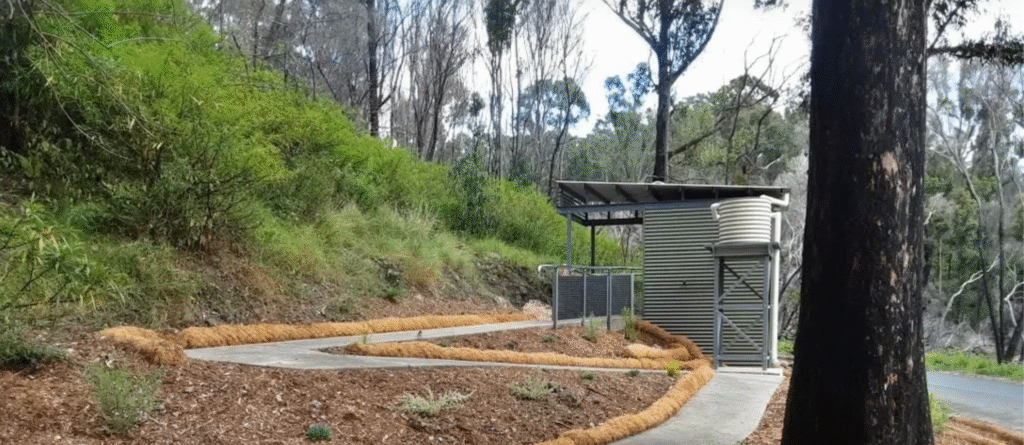 Side view of the Wonboyn toilet amenity at Myrtle Cove, set among native bush.