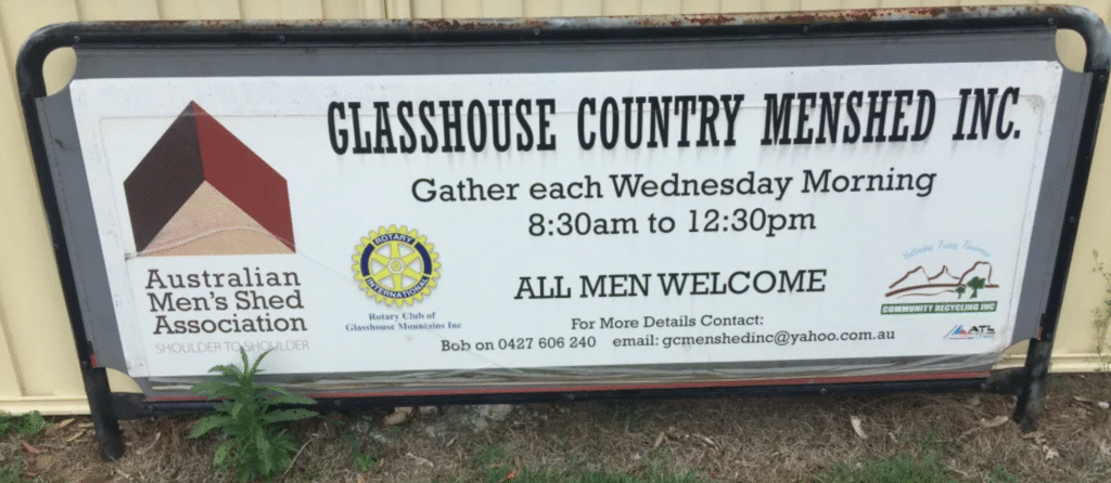 Close-up of Men’s Shed sign with opening hours and an invitation for men to join.