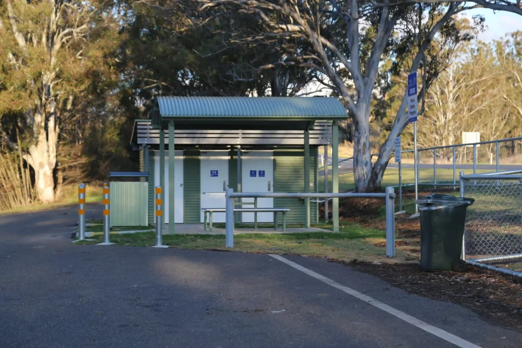 Front view of Queensland TMR restroom on concrete slab with accessible and ambulant cubicles plus storage room.