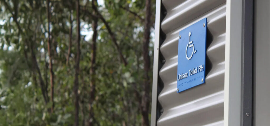 Close-up of accessible wheelchair symbol on the building—PWD accessible toilet facility.