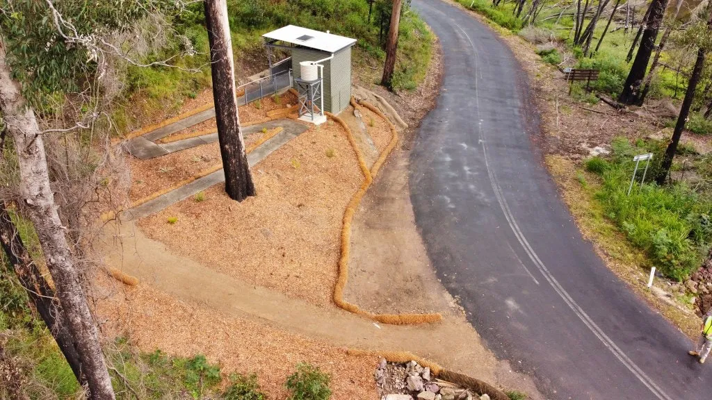 Distant view of the Wonboyn toilet amenity at Myrtle Cove with the approach path visible through bushland.